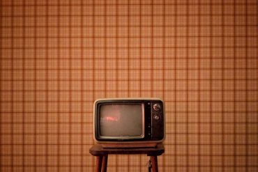 vintage television on a stall with vintage wallpaper background