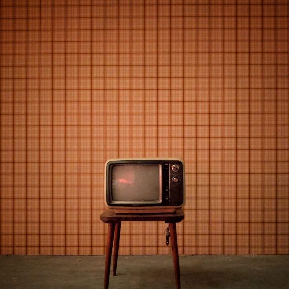 vintage television on a stall with vintage wallpaper background